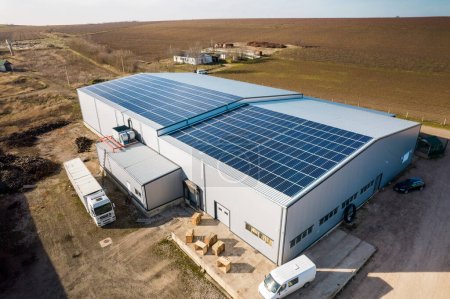 Foto de Vista aérea de drones de múltiples paneles solares en el techo de un edificio de fabricación en la naturaleza. Ecología temática - Imagen libre de derechos