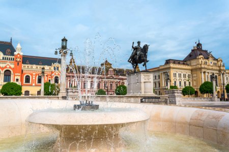 Vue sur la statue et la fontaine du roi Ferdinand I en face de celui-ci situé sur la place Unirii à Oradea au centre-ville, en Roumanie. Bâtiments de style classique sur le fond