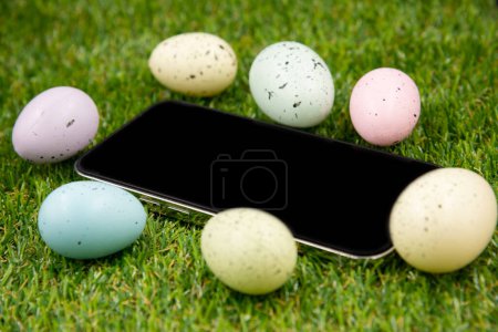Téléchargez les photos : Téléphone avec écran vide vierge sur fond d'oeufs de Pâques - en image libre de droit