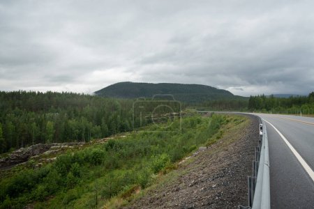 Landschaft mit Autobahn in den norwegischen Bergen, Fjorde an einem nebligen Tag