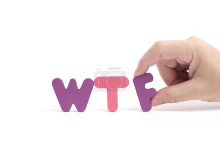 Foto de Man hand exposes abbreviation wtf in letters white background - Imagen libre de derechos