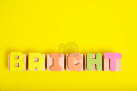 Téléchargez les photos : Word bright laid out multicolored letters yellow background - en image libre de droit