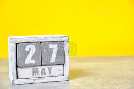 Photo for May 27 calendar made wooden cubes yellow background.With an empty space for your text - Royalty Free Image
