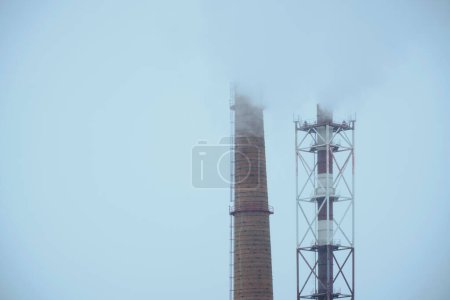 Photo for Two industrial pipes smoke polluting the environment with harmful gases - Royalty Free Image