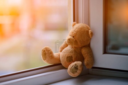 Ours enfants jouet doux assis bord d'une fenêtre ouverte.Accidents de concept avec des enfants