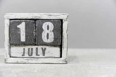 Téléchargez les photos : Calendrier pour le 18 juillet, en cubes de bois, sur fond gris. Avec un espace vide pour votre texte - en image libre de droit