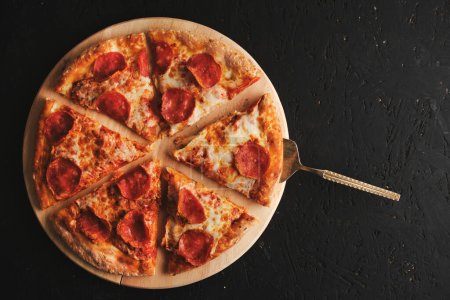 Téléchargez les photos : Pepperoni pizza avec saucisse fond foncé - en image libre de droit