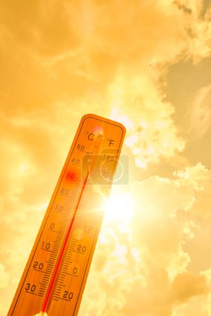 Termómetro contra fondo caliente, sol amarillo de verano.Clima caliente y alta temperatura del aire