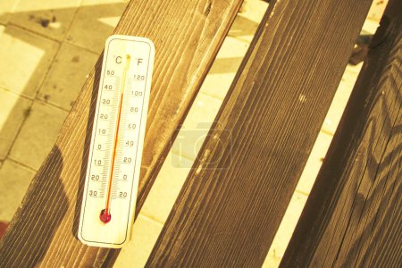 Photo for Thermometer on park bench hot day.High air temperature.Sultry summer - Royalty Free Image
