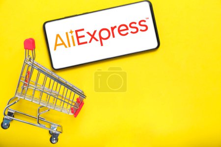 Photo for Kostanay, Kazakhstan, August 31, 2023. Smartphone with aliexpress logo,shopping basket yellow background.Concept online shopping - Royalty Free Image