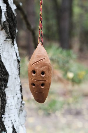 Téléchargez les photos : Ocarina, instrument de musique à vent suspendu à une branche de bouleau - en image libre de droit