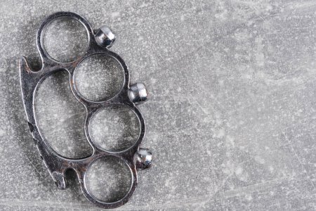 Photo for Metal brass knuckles, edged weapons concrete background - Royalty Free Image