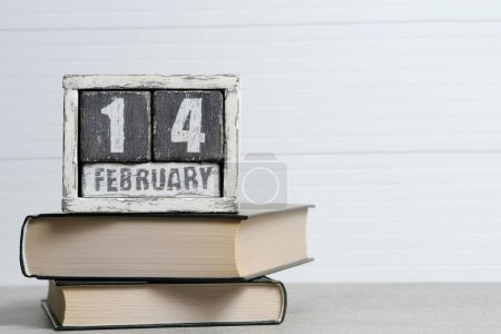 Photo for February 14th on the calendar and books on white background. International book giving day - Royalty Free Image