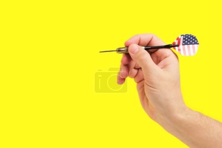 Hand hält US-Flagge Dart auf Gelb. Patriotisches Symbol, perfekt für Veranstaltungen im amerikanischen Stil oder Werbeaktionen