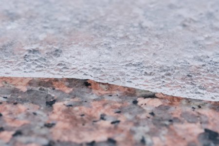 Photo for Melting ice partially covers granite tiles - Royalty Free Image