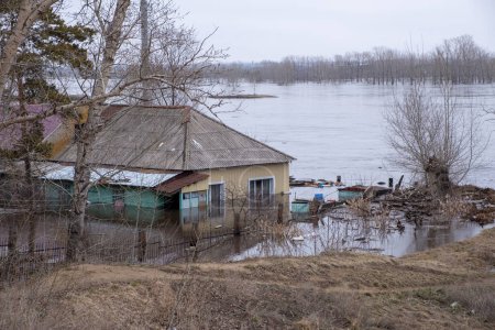 Altes Wohnhaus wird vom Wasser des über die Ufer tretenden Flusses überflutet. Naturkatastrophe