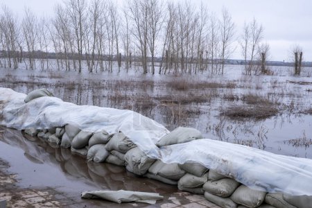 Sandbags protecting the road from flooding by the river