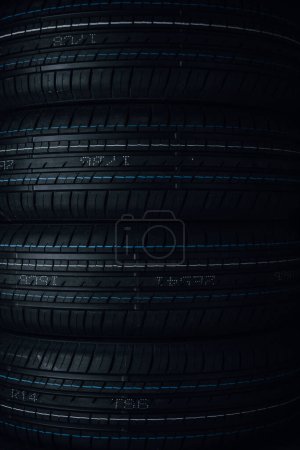 Car tires on black background. Tires stacked in a row