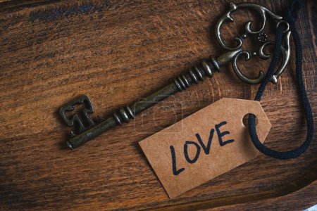 Vintage-Schlüssel mit Anhänger und der Aufschrift Liebe darauf. Konzept Liebe und Beziehungen