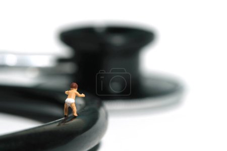 Foto de Miniatura gente pequeña juguete figura fotografía. Un niño pequeño caminando al estetoscopio. Aislado sobre fondo blanco. Foto de imagen - Imagen libre de derechos
