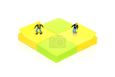 Téléchargez les photos : Creative miniature people toy figure photography. Sticky notes installation. The boys playing roller skater at skate park. Isolated on white background. Image photo - en image libre de droit
