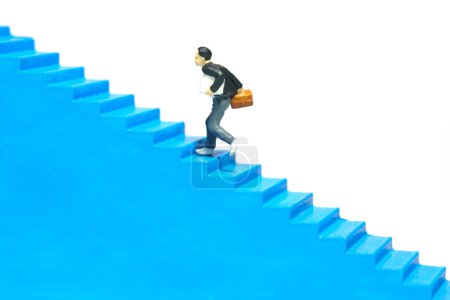Miniature people toy figure photography. A boy pupil student running on staircase. Isolated on a white background. Image photo