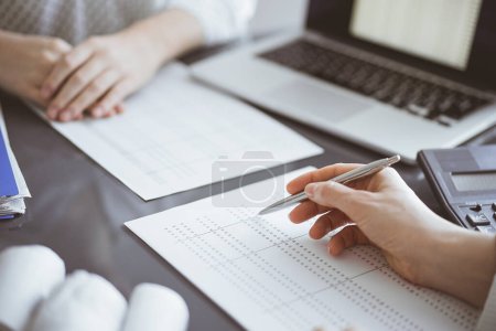 Foto de Una mujer contadora usando una calculadora y una computadora portátil mientras cuenta impuestos para un cliente. Conceptos de auditoría empresarial. - Imagen libre de derechos