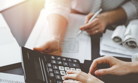 Foto de Una mujer contadora usando una calculadora y una computadora portátil mientras cuenta impuestos para un cliente. Conceptos de auditoría y finanzas empresariales. - Imagen libre de derechos