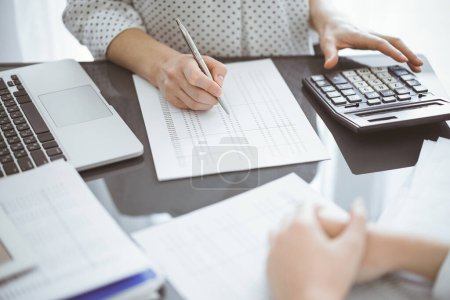 Foto de Una mujer contadora usando una calculadora y una computadora portátil mientras cuenta impuestos para un cliente. Conceptos de auditoría empresarial. - Imagen libre de derechos