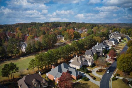 Téléchargez les photos : Vue aérienne panoramique d'une belle subdivision photographiée par un drone avec de belles maisons, des pelouses soignées et un arbre de couleur changeante pendant l'automne dans les banlieues d'Atlanta, GA, USA - en image libre de droit