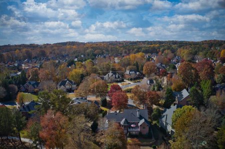 Téléchargez les photos : Vue aérienne panoramique d'une belle subdivision photographiée par un drone avec de belles maisons, des pelouses soignées et un arbre de couleur changeante pendant l'automne dans les banlieues d'Atlanta, GA, USA - en image libre de droit