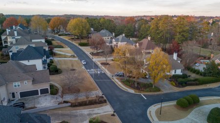 Téléchargez les photos : Vue aérienne panoramique de la grappe de maisons dans une subdivision de banlieue avec terrain de golf et lac dans le métro Atlanta en Géorgie, États-Unis tourné par drone tourné pendant l'heure d'or - en image libre de droit