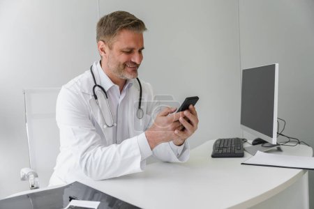 Foto de Médico profesional con las manos en el teléfono y charlando con el paciente. Medicina concepto en línea - Imagen libre de derechos
