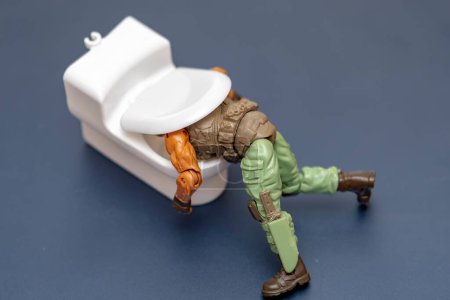Téléchargez les photos : Un soldat militaire vomit dans les toilettes, avec une attention sélective. Concept : intoxication alimentaire et alcoolique, vomissements et nettoyage gastrique ; Autriche, Vienne, 17 novembre 2022 - en image libre de droit