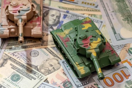 Zwei Militärpanzer, amerikanische Dollars, aus nächster Nähe. Konzept: Rüstungsausgaben, Militärhilfe, Handel mit Waffen und Munition, Geldkredite.