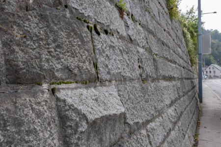 Foto de Muro de piedra inclinado, mantenimiento de mampostería de piedra para reforzar las laderas de una montaña. - Imagen libre de derechos