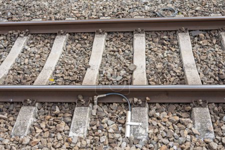 Foto de Los rieles ferroviarios se conectan a tierra con un cable metálico a las traviesas de hormigón. - Imagen libre de derechos