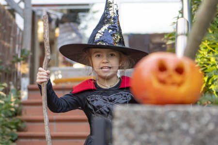 Téléchargez les photos : Fille en costume de sorcière avec balai, vacances d'Halloween, citrouille à thème orange. - en image libre de droit