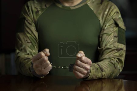 Photo for Military man in police handcuffs clenching fists, dark tone. Concept: arrest and investigative actions. - Royalty Free Image
