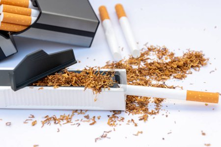 Zigarettenhüllen, Füllmaschine mit Tabak, leere Zigaretten und Zigarettenetui mit selbstgemachten Zigaretten auf weißem Hintergrund, Zigaretten zu Hause herstellen.