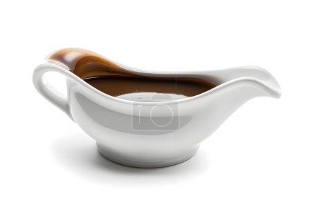 Ceramic gravy boat with sauce on white background