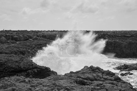 Téléchargez les photos : Une forte vague de vagues sur la côte rocheuse de l'Atlantique en noir et blanc - en image libre de droit