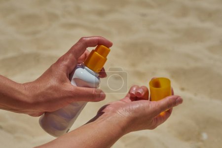 The hands of a girl who applies sunscreen