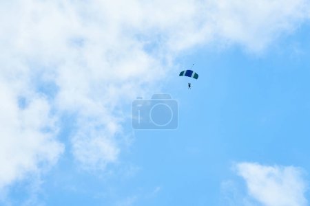 Photo for A parachutist in a blue sky under the clouds - Royalty Free Image