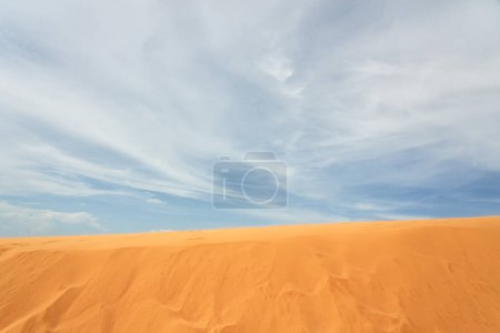 Sand dune in the desert with clouds in the background