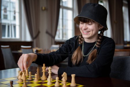 Téléchargez les photos : La fille joue aux échecs. Des morceaux sur l'échiquier. Jeu d'échecs, gros plan, portrait. Tournoi d'échecs, compétition - en image libre de droit
