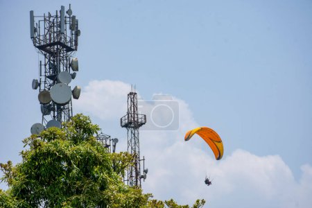 Paragliders fly around telecommunication antennae on top of mountain, Delo,  Kalimpong