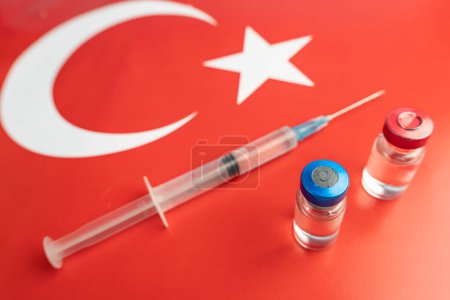 Pharmacology and Medicine Turkey concept. vaccine against coronavirus covid. Vaccine ampoules, syringe against the background of national flag. national pharmacological industry.