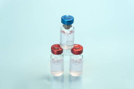 Téléchargez les photos : Flacons en verre médical pour échantillons liquides transparents sur fond bleu. Médecine, Pharmacologie, Laboratoire, Production macro - en image libre de droit