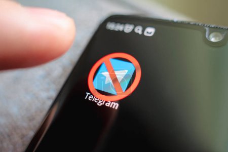 Foto de A crossed-out icon on a black smartphone screen. the concept of banning the application telegram. April 1, 2022. Barnaul. Russia - Imagen libre de derechos